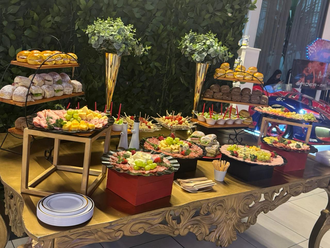 Mesa de coquetel com arranjo de eucalipto, frutas e tábuas de frios