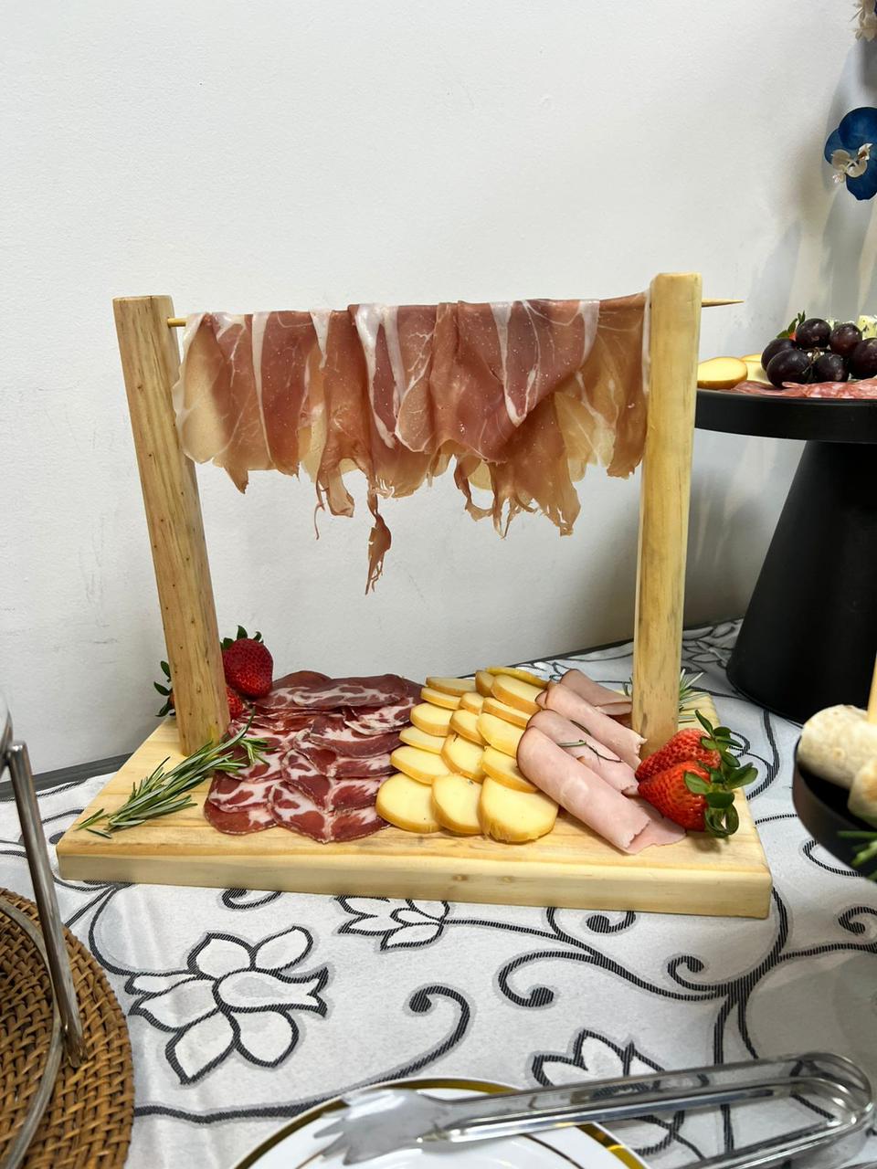 Prosciutto em display de madeira artesanal com queijos e morangos